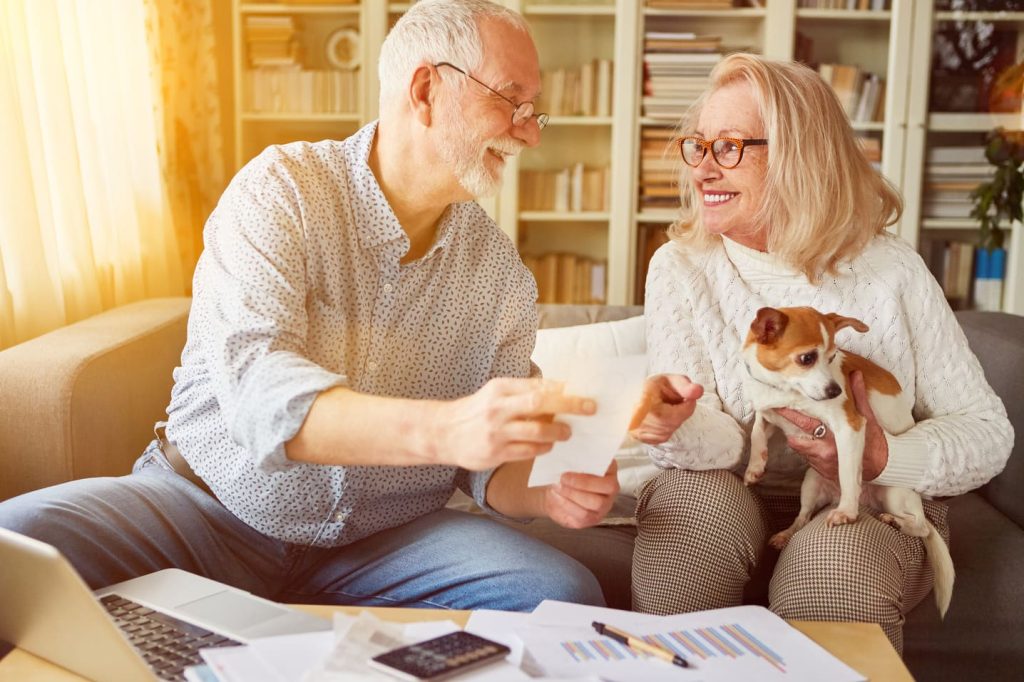 Ein Ehepaar mit Hund füllt die Steuererklärung aus.