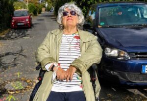 Annemie Ackermann sitzt auf ihrem Rollator.