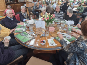 Senioren, die um einen runden Tisch während eines Ausflugs im Restaurant sitzen. 